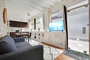 a living room with a couch and a large window at Very nice triplex apartment bright in Montorgueil in Paris