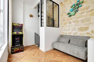 a living room with a couch and a stone wall at Very nice triplex apartment bright in Montorgueil in Paris