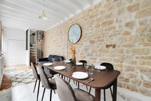 a dining room with a wooden table and chairs at Very nice triplex apartment bright in Montorgueil in Paris