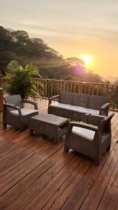 una terraza con mesa, sillas y puesta de sol en Minka Paradise, en Minca