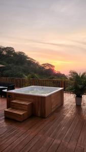 una bañera de hidromasaje en una terraza con vistas a la puesta de sol en el fondo en Minka Paradise, en Minca