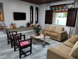 salon z kanapą i stołem w obiekcie Guarajuba Sereia House w mieście Guarajuba
