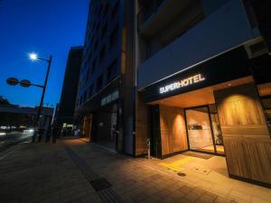 a store on the side of a street at night at Super Hotel Hiroshima in Hiroshima