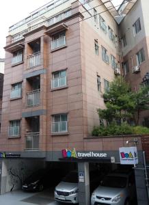 budynek z dwoma samochodami zaparkowanymi przed nim w obiekcie BoA Travel House w Seulu