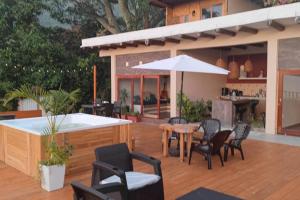 une terrasse avec des chaises, une table et un parasol dans l'établissement Minka Paradise, à Minca