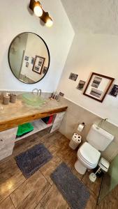 ein Badezimmer mit einem Waschbecken, einem WC und einem Spiegel in der Unterkunft El Satélite in Cordoba