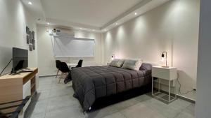 1 dormitorio con cama y pared blanca en Selbard Suite en Buenos Aires