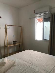 een slaapkamer met een wit bed en een raam bij Quarto Dani in Jericoacoara