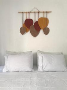 a bed with four hearts hanging on a wall at Quarto Dani in Jericoacoara