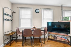 a dining room with a table and chairs and a tv at 2 Bed Townhouse: Minutes from DCA-National Airport in Alexandria