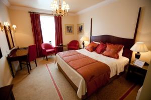 a bedroom with a large bed and a desk and chairs at Ringwood Hall Hotel & Spa in Chesterfield