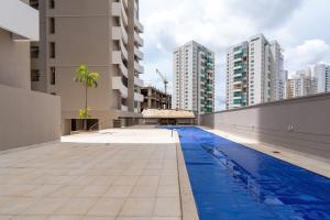 a swimming pool in a city with tall buildings at Tranquilidade e Conforto próximo ao Flamboyant in Goiânia