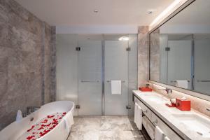 a bathroom with a tub and two sinks and a mirror at Hangzhou Junsun Luxury Hotel in Hangzhou +13 photos
