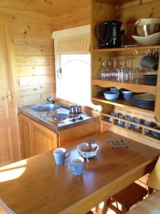 - une cuisine avec une table en bois et un évier dans l'établissement Les Roulottes-Gîtes de la Ferme de l'Autruche Dromoise, à Livron-sur-Drôme
