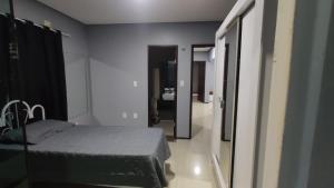 1 dormitorio con 1 cama y pasillo con baño en Duplex com piscina no Grangeiro, en Crato