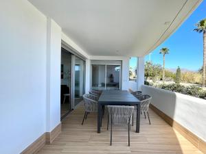 Un comedor con mesa y sillas en un balcón. en Chic Beachside Getaway, en Motril