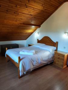 1 dormitorio con 1 cama grande y techo de madera en Quinta dos Carvalhos, en Vila Praia de Âncora