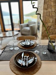 a table with two plates and silverware on a table at Mount Log Cabin in Mavrovo