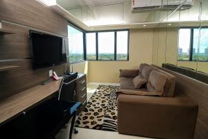 a living room with a couch and a flat screen tv at Tropical Executive Flat 1006 Bed Room Suite Veiw in Manaus
