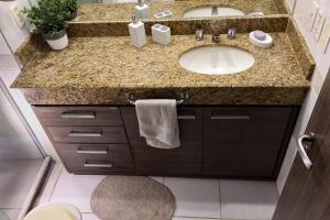 a bathroom with a sink and a granite counter top at Tropical Executive 1006 in Manaus