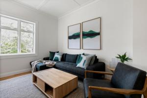 a living room with a couch and a coffee table at The Village Reserve Boutique Accomodation in Auckland