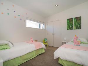 a bedroom with two beds and a window at Aquila Waters - Whitianga Holiday Home in Whitianga