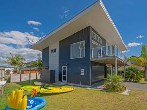 a house with two kayaks in front of it at Aquila Waters - Whitianga Holiday Home in Whitianga