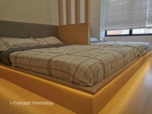 a large bed with a wooden frame in a bedroom at I-Concept Homestay in Kuala Lumpur