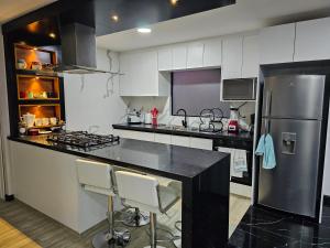 a kitchen with a black counter and a refrigerator at apartamento de lujo in Cuenca