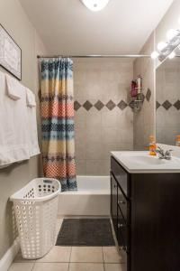 ein Bad mit einer Badewanne, einem Waschbecken und einer Dusche in der Unterkunft ONE ROOM in AN APT HAVEN in Chicago