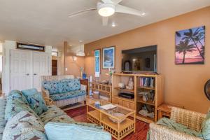 a living room with two couches and a tv at Maui Sands #5G in Kahana