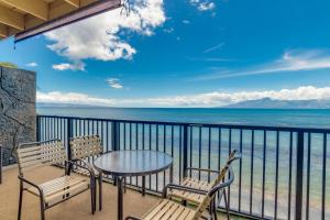 a balcony with a table and chairs and the ocean at Maui Sands #5G in Kahana