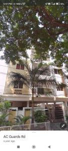 ein Gebäude mit einer Palme davor in der Unterkunft B S Homes in Hyderabad