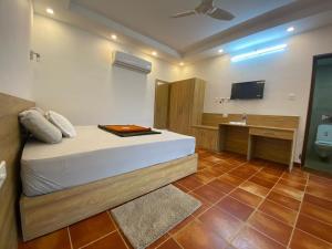 a bedroom with a bed and a desk and a television at Athirappilly Heritage Villa in Athirappilly