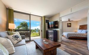 een woonkamer met een bed en een groot raam bij Refined Oceanfront Retreat in Kihei
