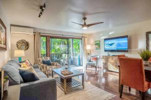 a living room with a couch and a flat screen tv at Tropical & Serene Ground Floor in Kihei