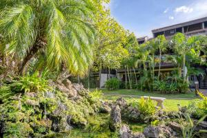 a palm tree in front of a building at Tropical & Serene Ground Floor in Kihei