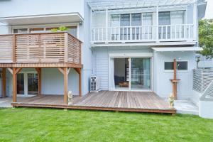 a house with a wooden deck in the yard at MORITO Funny house in Hayama