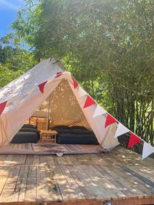 ein Zelt auf einer Holzterrasse mit Bäumen im Hintergrund in der Unterkunft Homestay Sake in Lai Sơn