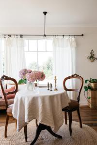 a dining room with a table with two chairs and a window at Ocean beach front, 3 Capes Cottage. in Eaglehawk Neck