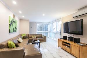 a living room with a couch and a flat screen tv at Torquay Retreats - Anderson in Torquay