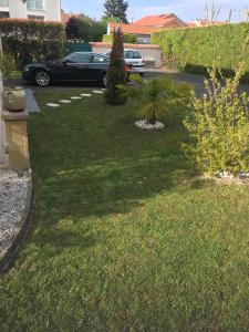 a yard with a car parked in a driveway at Charmante et agréable chambre dans une villa calme in Andrézieux-Bouthéon