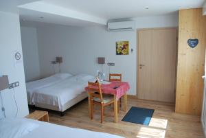 1 dormitorio con cama y mesa con manta rosa en Chambres d'hôtes Les vignes en Saint-Jean-Saverne