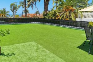 a yard with green grass and a fence at Villa Terraza del Teide in Puerto de la Cruz