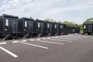 a row of black containers sitting in a parking lot at HOTEL R9 The Yard Sosa in Sosa