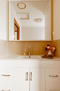 a white kitchen with a sink and a mirror at Freshwater Creek Cottages & Farm Stay in Torquay