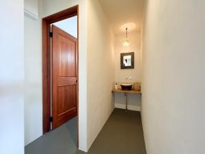 a hallway with a wooden door and a sink at THE SECOND Kujukuri Beach House in Kujukuri