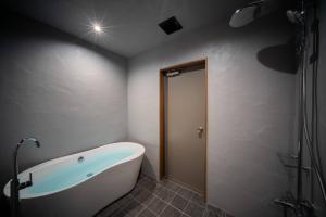 a bathroom with a bath tub and a shower at THE SECOND Kujukuri Beach House in Kujukuri