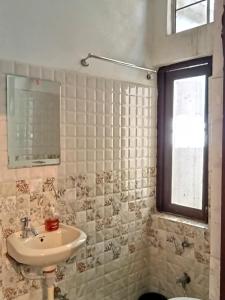 uma casa de banho com um lavatório, um WC e uma janela. em Cocoon Auberge em Jaipur