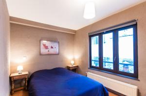 Un dormitorio con una cama azul y una ventana en Zen Appart Vieux Lille 2, en Lille